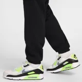 Pantalón de jogging negro con cintura elástica ajustable con cordón, bolsillos laterales y bolsillo cargo con solapa en la pierna. Logo de Nike bordado en blanco en la cadera izquierda.