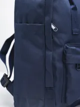 Mochila color bordó con diseño clásico y minimalista. Cuenta con un compartimento principal con cierre, un bolsillo frontal con cierre y un bolsillo interior. Tiene asas superiores y correas ajustables para los hombros. El logo de "Forum Industries Co." está en un parche redondo en la parte frontal.