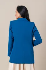 Blazer azul eléctrico de crepe y spandex, corte clásico, con solapas de muesca, cierre cruzado con botones forrados y bolsillos con solapa.