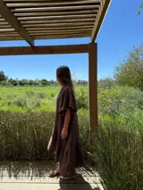 Vestido verde oliva de lino, corte suelto, con mangas abullonadas y volado en el ruedo.