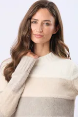 Buzo tejido de punto con diseño de rayas horizontales en tonos gris, rosa, malva y beige. Presenta cuello redondo, mangas largas y puños acanalados, con una pequeña etiqueta de cuero sintético en el ruedo.