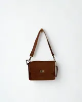 Cartera bandolera de cuero color marrón, con solapa frontal, cierre metálico tipo torniquete y correa ajustable con detalles de cadena.