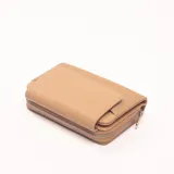 Billetera marrón con cierre de cremallera y diseño con paneles lisos y texturizados.