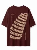 Remera marrón oscuro de corte oversize, con cuello redondo y mangas cortas. Presenta un pequeño estampado con la palabra "Suns" en tono beige en el pecho.