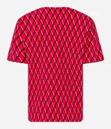 Blusa de crepé color rojo con estampado geométrico de rombos en negro y blanco. Tiene cuello redondo con abertura en forma de gota y detalle metálico, mangas cortas y corte recto.