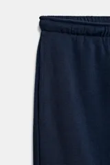 Pantalón jogger de tiro alto y color azul marino, con cintura elástica ajustable mediante cordones con herretes metálicos y puños elásticos en los tobillos.