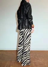 Pantalón largo de viscosa con estampado animal print tipo cebra en tonos beige y negro, de corte recto y holgado.