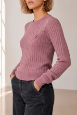 Sweater tejido de punto color celeste, con diseño de ochos verticales, cuello redondo y manga larga. Presenta detalles de bordado pequeño en el pecho.