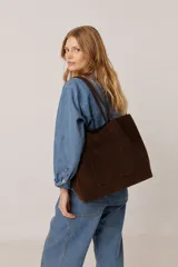 Cartera tipo tote bag marrón de gamuza, de gran capacidad, con asas largas para llevar al hombro y bolsillo frontal externo.