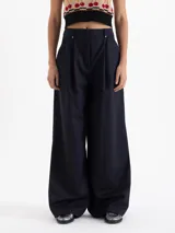 Pantalon de vestir azul marino con corte wide leg, tiro alto y pinzas frontales que aportan volumen. Cuenta con cierre frontal, doble gancho de ajuste y presillas con detalles de remaches metálicos.