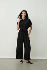 Mono largo negro de corte palazzo con camisa de mangas cortas con botones y lazo en la cintura.