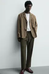Pantalón de corte relajado confeccionado en una mezcla de algodón y lino. Presenta cintura elástica con cordón ajustable, bolsillos laterales y bolsillos traseros de vivo.