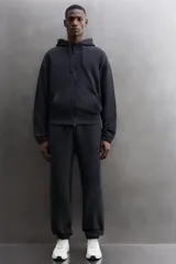 Sudadera con capucha y cierre de cremallera de doble dirección, color negro, de corte relaxed fit, con bolsillos frontales tipo canguro y puños y bajo elásticos.