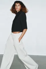 Blazer cropped de corte estructurado, con cuello subido, manga corta y cierre frontal con un botón. Presenta un bolsillo de vivo en el pecho y forro interior a tono.