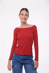 Top de punto color ladrillo, de mangas largas y escote bote con terminaciones onduladas.