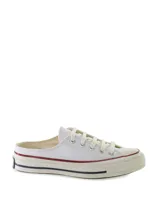 Zapatillas tipo mule Converse Chuck 70, confeccionadas en lona de algodón color blanco. Presentan el diseño clásico de la puntera de goma, cordones al tono y suela de goma con la característica franja roja y azul.