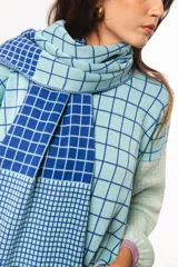 Bufanda tejida a crochet con diseño a cuadros en celeste y azul.