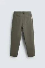Pantalón de corte carrot fit confeccionado en tejido de algodón con estructura diagonal y efecto lavado. Presenta bolsillos frontales con bolsillo cerillero, bolsillos traseros de plastrón y cierre frontal con cremallera y botón.