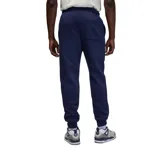 Pantalon de jogging Nike Jordan, confeccionado en tejido fleece color negro, con cintura elástica ajustable mediante cordón, puños elásticos en los tobillos y logo Jumpman bordado en color rojo en la pierna izquierda.