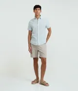 Camisa de corte regular confeccionada en mezcla de lino y algodón, con cuello inglés, manga corta y cierre frontal abotonado. Diseño liso en color beige de la marca Marfinno.