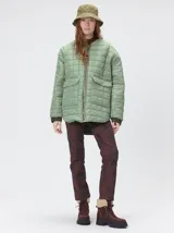 Campera reversible capitoneada con cierre frontal. Un lado es de color negro y el otro es de color beige, ambos con diseño acolchado. Cuenta con cuello redondo, mangas largas y bolsillos laterales.