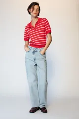 Jeans de tiro alto con diseño de cintura cruzada, cinco bolsillos y pernera recta con bajo sin costura. Cierre frontal con cremallera y botones.