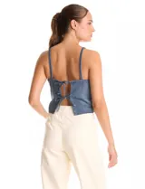Top corto de denim azul con apliques de strass en toda la superficie. Presenta escote en V, breteles finos y espalda abierta con ajuste mediante lazos.