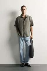 Jeans regular fit confeccionados en denim de algodón celeste con efecto lavado, de cinco bolsillos y cierre frontal con cremallera y botón.