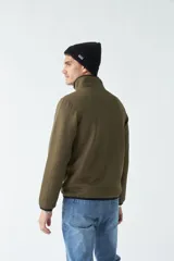 Campera azul marino con cuello alto y bolsillos laterales con cierre.