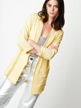 Blazer oversized lila de corte recto, largo a la cadera, con hombreras finas forradas, costuras internas con sesgo combinado y maxi bolsillos delanteros. Incluye lazo de algodón con detalle a tono.