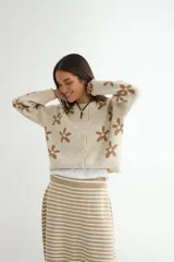 Cardigan de punto con estampado de flores, cuello redondo y cierre frontal con botones. Presenta un diseño de corte holgado con puños y ruedo acanalados.