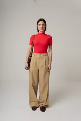 Pantalón de vestir color beige, de corte palazzo, con bolsillos laterales y traseros.