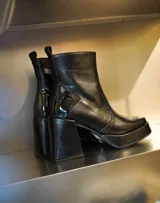 Bota de cuero marrón con textura croco, taco alto ancho y plataforma delantera, con cierre lateral y puntera cuadrada.