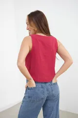 Top bordeaux de escote recto y tirantes anchos con aplicación de tachas doradas.