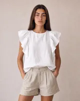 Blusa blanca de lino 100% natural, sin mangas, con cuello redondo y volados aplicados en los hombros.