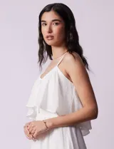 Vestido midi blanco de gasa bambula marca Lily Black, con escote redondo, breteles regulables y lazo de ajuste. Presenta una sobrecapa en el torso y un forro interno a tono. El largo de la espalda es mayor al largo delantero.