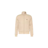 Campera deportiva Lacoste de color beige, con cierre frontal completo, cuello alto y bolsillos laterales. Presenta un estampado monograma en toda la prenda y el icónico logotipo del cocodrilo bordado en el pecho.