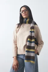 Polera de tejido liviano color negro con cuello alto y silueta relajada. Presenta mangas largas con puños ajustados y recortes laterales que aportan estructura al diseño.