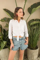 Camisa blanca de lino, de corte clásico, con cuello camisero, manga larga y bolsillo en el pecho.