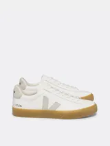 Championes Veja modelo Campo, de diseño minimalista en color blanco con detalles en gris claro. Presentan el logo lateral en forma de V, suela de goma color caramelo y cierre mediante cordones.