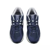 Championes New Balance modelo 1906R, color azul marino con detalles en gris y blanco. Presentan una construcción en malla transpirable con superposiciones sintéticas y entresuela con tecnología N-ergy.