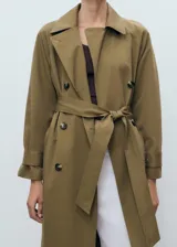 Abrigo tipo trench de diseño recto y oversize, color verde oliva. Presenta cierre de doble botonadura, cuello de solapa ancha, bolsillos laterales y mangas largas con puños abotonados. Incluye forro interior y cinturón desmontable.