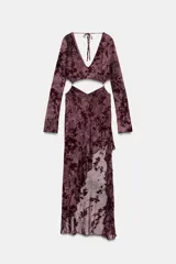 Vestido midi confeccionado en tul semitransparente con diseño de flores flocadas. Presenta escote en pico, mangas largas, aberturas laterales tipo cut out en la cintura y bajo asimétrico con volados. Incluye forro interior y cierre en la espalda con lazadas.