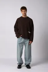 Sweater de punto liviano color negro con textura marcada, diseño de cuello redondo y calce holgado.