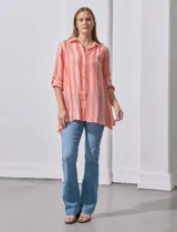 Camisa larga de rayón, con cuello clásico, cierre frontal con botones y mangas regulables con presilla. Presenta un diseño holgado con tajos laterales en el ruedo.