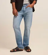 Pantalón de jean masculino, modelo slim, con lavado claro y pequeños desgastes en los bolsillos. Confeccionado en denim con elastano.