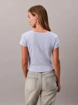 Remera Calvin Klein Jeans de manga corta, color celeste, confeccionada en tejido de punto acanalado con diseño ceñido tipo baby tee y cuello redondo. Presenta una pequeña etiqueta con el logo de la marca centrada en el pecho.