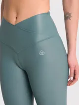 Calza deportiva color verde azulado, tiro alto, sin bolsillos y tela brillante.