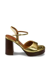 Sandalias de tacón alto con plataforma, color dorado metalizado y pulsera al tobillo con hebilla.