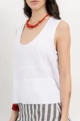 Musculosa blanca de algodón orgánico con escote en U, cortes irregulares y mezcla de texturas. Tiene un fit holgado y cinta aplicada en la espalda con bordado frutal.